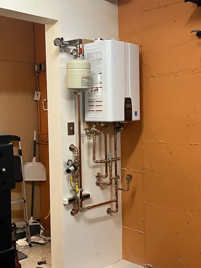 Plumbing technician inspecting water heater connections in Burlington